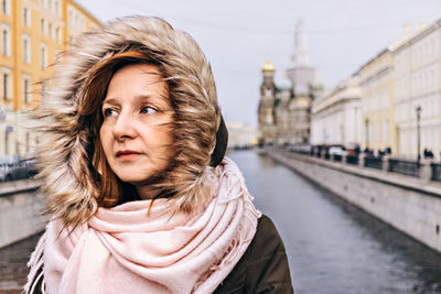 Portrait of woman standing in city during winter