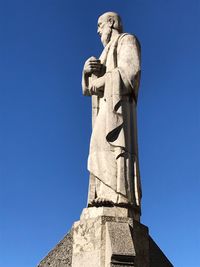 Low angle view of statue against blue sky