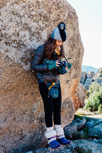 Full length of woman standing by rock