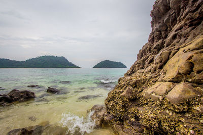 Scenic view of sea and mountains against sky