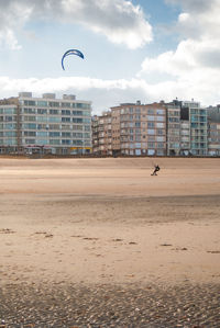 Kitesurfer riding on a sandy beach at the belgium coast at autumn