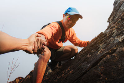 Young man looking at camera against clear sky