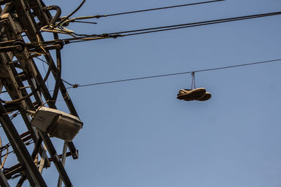 Low angle view of electricity pylon against clear blue sky