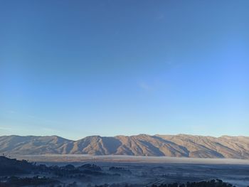 Scenic view of mountains against blue sky