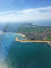 Aerial view of landscape by sea against sky