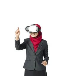 Man holding smart phone while standing against white background