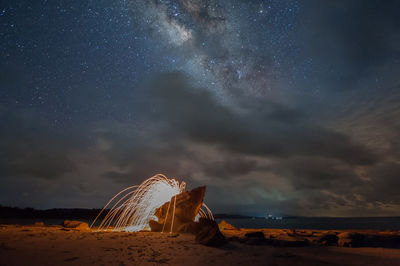 Ferris wheel on land against sky at night