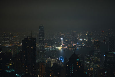 Illuminated cityscape against sky at night