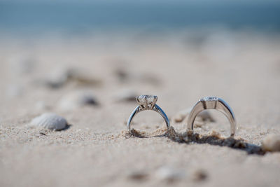 Close-up of wedding rings on sand