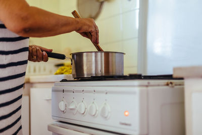 Midsection of man preparing food in kitchen at home