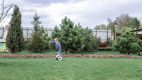 Full length of boy on field against sky