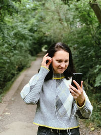 Young woman is walking in the park and talking to her friends with using video chat.casual lifestyle