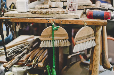 Whisk brooms hanging from workbench in jewelry workshop