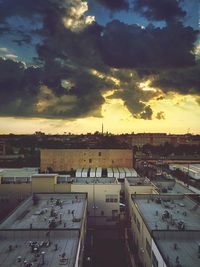 Buildings against cloudy sky at sunset