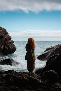 Rear view of woman looking at sea against sky