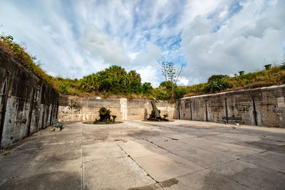 Old ruin amidst trees in city against sky