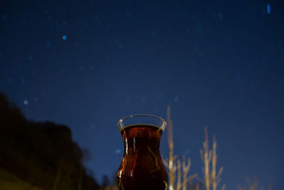 Close-up of beer bottle against sky