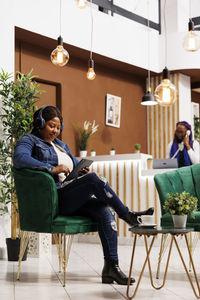 Side view of woman using mobile phone while sitting at home