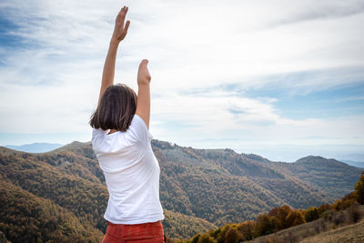 Rear view of man looking at mountains against sky