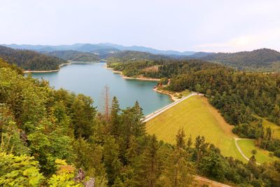 High angle view of lake amidst trees in forest against sky