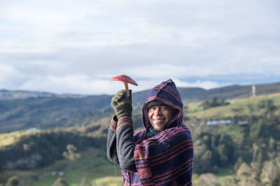 Rear view of woman with umbrella against sky