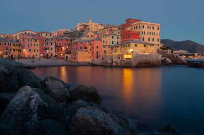 Buildings by sea against sky in city