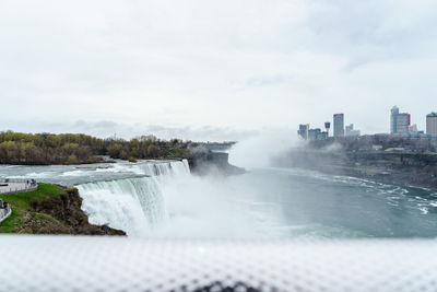 Scenic view of waterfall against sky