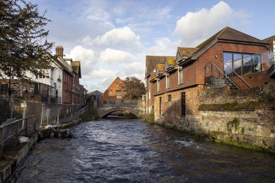 Canal amidst buildings against sky