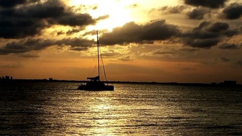 Boat sailing in sea at sunset