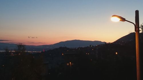 Illuminated cityscape against sky at dusk