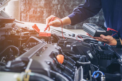 Midsection of mechanic repairing car