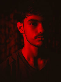 Close-up portrait of young man against black background