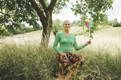 Portrait of young woman standing on field