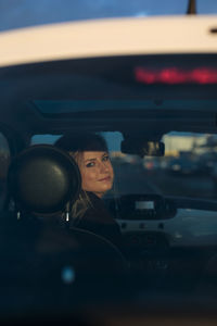 Reflection of young woman in car