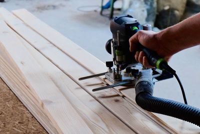 Carpenter cutting wood with machine