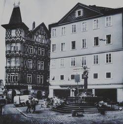 People on street against buildings in city