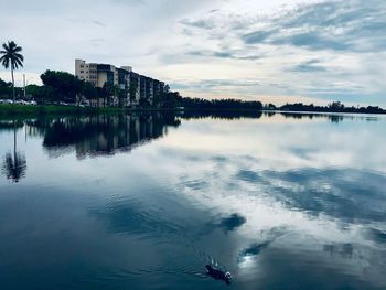 Scenic view of lake by buildings against sky