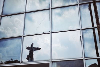 Low angle view of modern building against cloudy sky