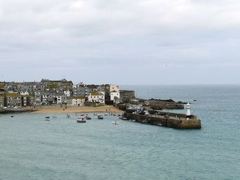 Scenic view of sea by buildings against sky