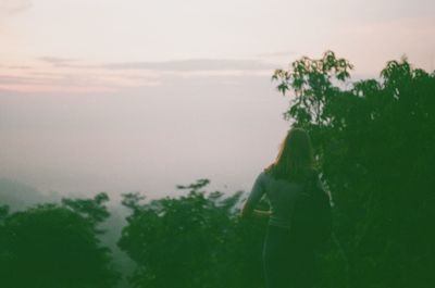 Rear view of woman on landscape against sky