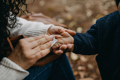 Mother cleaning dirty hands of son