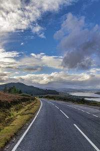 Surface level of empty road against cloudy sky