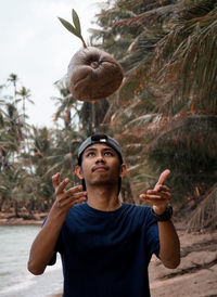 Man throwing coconut at beach