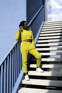 Woman standing on staircase of building