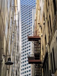 Low angle view of buildings in laneway in city.