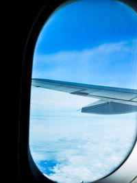View of cloudy sky seen through airplane window