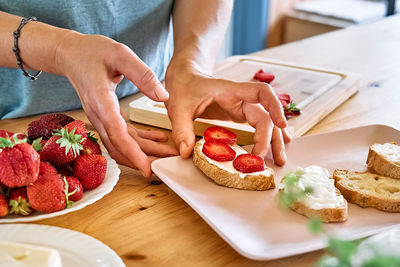 Woman making summer strawberry sandwich. 