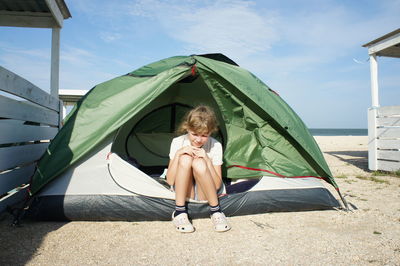 Rear view of woman relaxing in tent