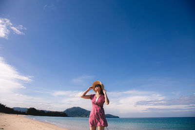 Woman standing in sea against sky