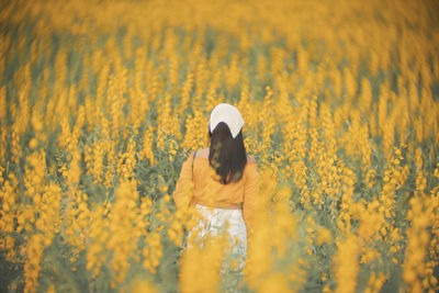 Rear view of person standing on field
